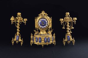 TRITTICO - H cm 32 e 30 composto da pendola da tavolo e coppia di candelieri a tre luci in bronzo dorato con inserti ovali  [..]