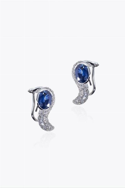 COPPIA DI ORECCHINI : Peso gr 10 in oro bianco  a lobo  a volute in diamanti taglio brillante per totali ct 0 80 ca  terminanti con due zaffiri Ceylon taglio ovale per totali ct 3 0 ca  - Asta Asta 205 Gioielli - Associazione Nazionale - Case d'Asta italiane