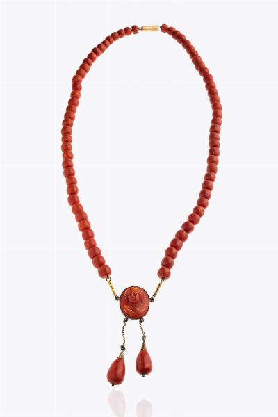 COLLANA : Peso gr 69 2 Lunghezza cm 58 composta da barilotti di corallo rosso mediterraneo del diam. di mm 7 3 a 9 ca; al centro cammeo inciso con volto femminile e due frange a goccia in corallo pendenti. Chiusura in oro rosa a bassa caratura Accompagnato da certificato  telematico di autenticit Ce.S.Ar. Centro Studi Archeometrici.  - Asta Asta 205 Gioielli - Associazione Nazionale - Case d'Asta italiane