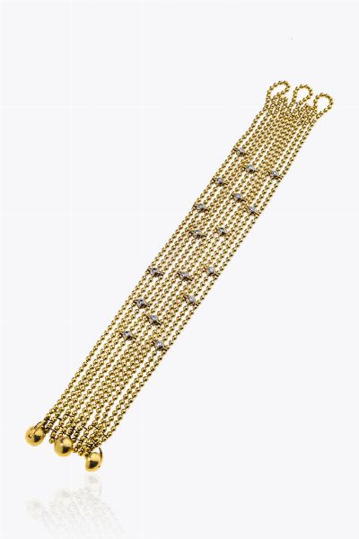 CARTIER : Peso gr 56 5 Lunghezza cm 19 Bracciale in oro giallo  firmato Cartier  modello Draperie  composto da dieci fili in sfere e diamanti taglio brillante per totali ct 0 70 ca  probabile colore G-H  purezza IF-VVS  - Asta Asta 205 Gioielli - Associazione Nazionale - Case d'Asta italiane