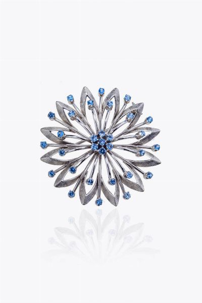 SPILLA : Peso gr12 1 Diam. cm 4 in oro bianco satinato a forma di rosone con pietre sintetiche azzurre  - Asta Asta 205 Gioielli - Associazione Nazionale - Case d'Asta italiane