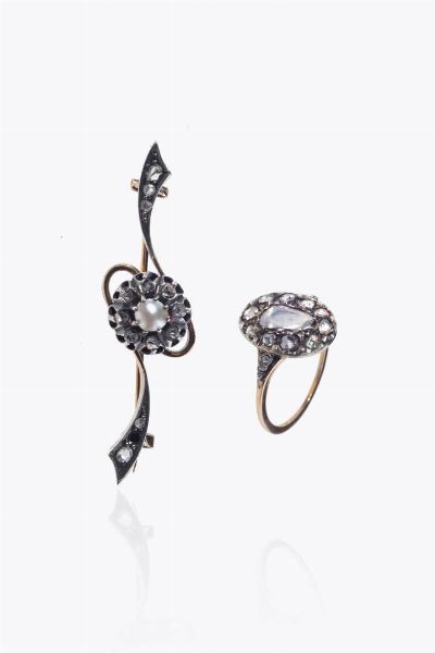 LOTTO DI DUE GIOIELLI : composto da: -spilla a barretta in oro a bassa caratura ed argento  XIX secolo  sommit con volute e fiore in rosette di diamanti per totali ct 0 15 (una mancante) e perle giapponese. Peso gr 5 4 -anello in oro rosa a bassa caratura ed argento  XIX secolo  con rosette di diamanti per totali ct 0 65 ca. Peso gr 3 3. Misura 14(54)  - Asta Asta 205 Gioielli - Associazione Nazionale - Case d'Asta italiane