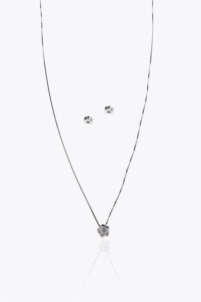 DEMI-PARURE : Peso gr 3 6 composta da coppia di orecchini e catena con ciondolo a forma di fiore stilizzato con diamanti taglio brillante per totali ct 0 03 ca  probabile colore G-H  purezza IF-VVS  - Asta Asta 205 Gioielli - Associazione Nazionale - Case d'Asta italiane