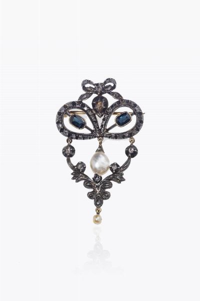 SPILLA : Peso gr 11 4 in oro rosa a bassa caratura ed argento  XIX secolo  a volute con due zaffiri taglio ovale; rosette di diamanti e due perle (mancanze)  - Asta Asta 205 Gioielli - Associazione Nazionale - Case d'Asta italiane