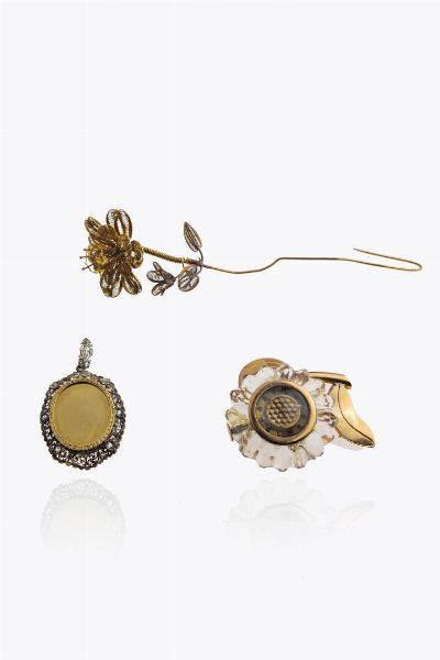LOTTO DI TRE GIOIELLI : composto da: -spilla-orologio in oro rosa a forma di girasole con petali in cristallo (rotture). Orologio non funzionante. Peso lordo gr 25 -Fiore in oro lavorato a filigrana. Peso gr 5 1 -Ciondolo in oro a bassa caratura ed argento  XIX secolo  con lastra centrale atta da essere incisa e rosette di diamanti per totali ct 0 10 ca. Peso gr 5 0  - Asta Asta 205 Gioielli - Associazione Nazionale - Case d'Asta italiane