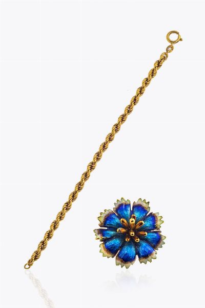 LOTTO DI DUE GIOIELLI : composto da: -bracciale in oro giallo  lavorato a torchon. Peso gr 3 8. Lunghezza cm 15 -spilla in oro giallo a forma di fiore in smalti policromi. Peso gr 8 1. Diam. cm 2  - Asta Asta 205 Gioielli - Associazione Nazionale - Case d'Asta italiane