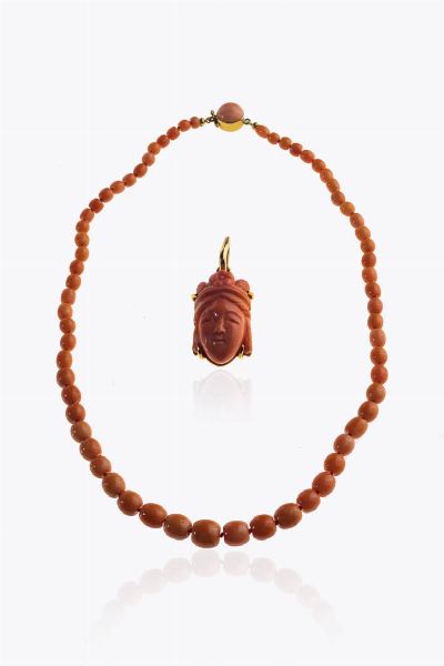 LOTTO DI DUE GIOIELLI : -ciondolo in oro giallo con corallo cabochon nei toni del salmone con inciso il volto di un orientale. Peso gr 3 7 -collana composta da sfere di corallo color salmone a scalare dal diam di mm 4 4 a mm 8 9. Chiusura in oro giallo con semisfera di corallo. Peso gr 23 4. Lunghezza cm 42 Accompagnato da certificato  telematico di autenticit Ce.S.Ar. Centro Studi Archeometrici.  - Asta Asta 205 Gioielli - Associazione Nazionale - Case d'Asta italiane
