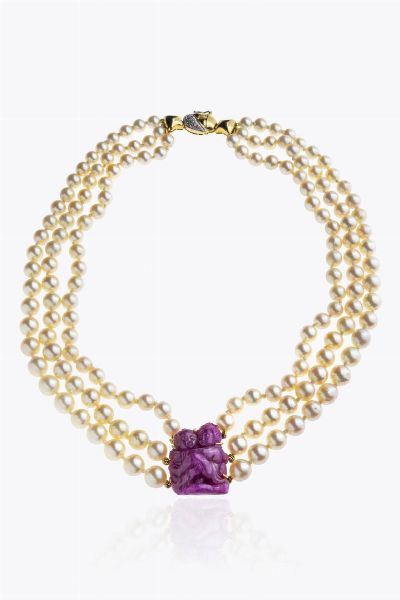 COLLANA : Lunghezza cm 45 composta da tre fili di perle giapponesi a scalare dal diam. di mm 6 8 a 8 7  al centro ciondolo in radice di rubino inciso con scena erotica. Chiusura geometrica in oro giallo con diamanti taglio 8/8 per totali ct 0 15 ca  - Asta Asta 205 Gioielli - Associazione Nazionale - Case d'Asta italiane