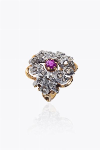 ANELLO : Peso gr 8 8 Misura 20 (60) in oro rosa e bianco14 Kt   sommit a volute  al centro rubino centrale di ct 0 35 ca  e rosette per totali ct 0 40 ca  - Asta Asta 205 Gioielli - Associazione Nazionale - Case d'Asta italiane