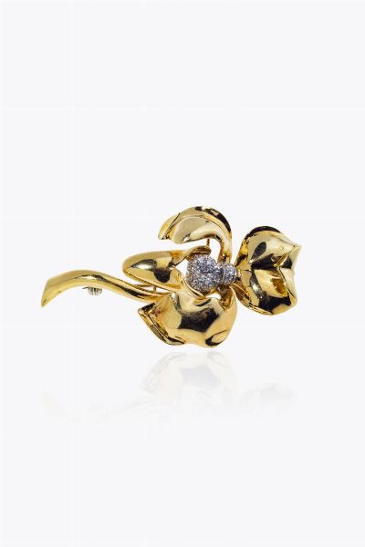 SPILLA : Peso gr 20 7 cm 3 5x6 5 in oro giallo  a forma di iris  con al centro diamanti taglio brillante per totali ct 0 25 ca  - Asta Asta 205 Gioielli - Associazione Nazionale - Case d'Asta italiane