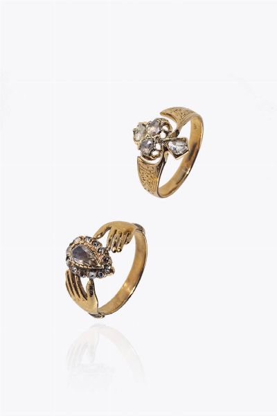 LOTTO DI DUE ANELLI : composto da: -anello in oro rosa a bassa caratura e argento  XIX secolo  con quattro rosette di diamanti per totali ct 0 45. Peso gr 3 5. Misura 14 (54) -anello in oro rosa a basa caratura  sommit con due mani trattenenti una rosetta di diamante taglio  a goccia e piccoli rosette a decori per totali ct 0 40ca. Peso gr 3 3. Misura 18 (58) -  - Asta Asta 205 Gioielli - Associazione Nazionale - Case d'Asta italiane