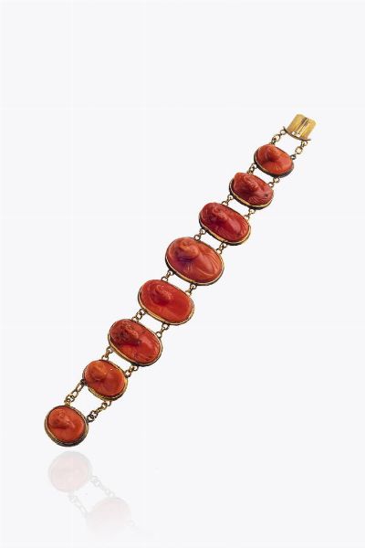 BRACCIALE : Peso gr 18 6 Lunghezza cm 15 composto da cammei a scalare in corallo inciso con volti femminili (difetti)  montato in oro a bassa caratura  XIX secolo Accompagnato da certificato  telematico di autenticit Ce.S.Ar. Centro Studi Archeometrici.  - Asta Asta 205 Gioielli - Associazione Nazionale - Case d'Asta italiane