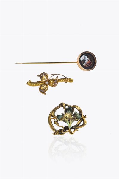 LOTTO DI TRE GIOIELLI : composto da: -spilla in oro giallo  inizi XX secolo  con fiore in smalto. Peso gr 3 4 -spilla in oro giallo  inizi XX secolo  a forma di trifoglio con perline. Peso gr 2 5 -spillone in oro rosa a bassa caratura  con smalto raffigurante il profilo di un cane. Peso gr 3 6  - Asta Asta 205 Gioielli - Associazione Nazionale - Case d'Asta italiane