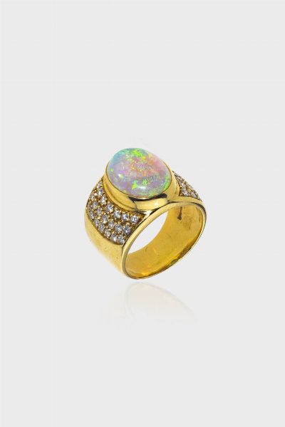ANELLO : Peso gr 12 4 Misura 12 (52) in oro giallo  a fascia  con al centro opale taglio cabochon e pav di diamanti taglio brillante per totali ct 0 50 ca  - Asta Asta 205 Gioielli - Associazione Nazionale - Case d'Asta italiane