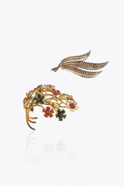 LOTTO DI DUE SPILLE : in oro giallo: -a forma di ramo fiorito con smalti policromi e zaffiri  rubini. Peso gr 11 5 -a forma di tre foglie di selce. Peso gr 3 1  - Asta Asta 205 Gioielli - Associazione Nazionale - Case d'Asta italiane