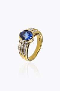 ANELLO - Peso gr 7.20 Misura 12 (52) in oro giallo  al centro zaffiro taglio ovale di ct 2 ca  ai lati due file di diamanti  [..]