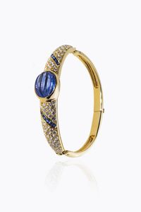 BRACCIALE - Peso gr 30 rigido in oro giallo con al centro zaffiro cabochon fesonato di ct 6 50 ca; diamanti taglio brillante  [..]