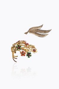 LOTTO DI DUE SPILLE - in oro giallo: -a forma di ramo fiorito con smalti policromi e zaffiri  rubini. Peso gr 11 5 -a forma di tre foglie  [..]