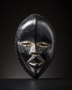 Dan - Costa d'Avorio/Liberia - Maschera Dan.Legno duro a patina lucida, pigmento nero e metallo.Segni d'uso.