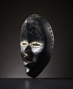 Dan - Costa d'Avorio/Liberia : Maschera Dan.Legno duro a patina lucida, pigmento nero e metallo.Segni d'uso.  - Asta Asta 365 | ARTE AFRICANA, OCEANICA E DELLE AMERICHE - ARTE AFRICANA Tradizionale - Associazione Nazionale - Case d'Asta italiane