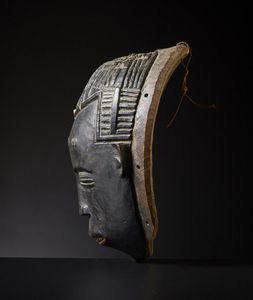 Guro - Costa d'Avorio : Maschera Gugu.Legno duro a patina scura.Difetti, mancanze e notevoli segni d'uso.  - Asta Asta 365 | ARTE AFRICANA, OCEANICA E DELLE AMERICHE - ARTE AFRICANA Tradizionale - Associazione Nazionale - Case d'Asta italiane