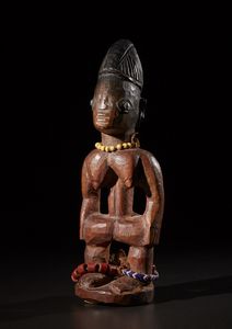 Yoruba -Nigeria - Ibeji singolo.Legno duro a patina rossastra, perline, metallo e pigmenti.Segni d'uso.