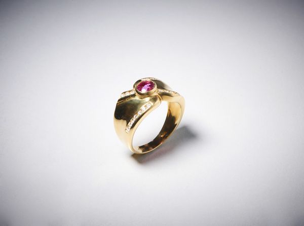 . : Anello a ''fascia'' in oro giallo  750/1000 con rubino centrale ovale di circa  0,35 carati con contorno di diamanti bianchi taglio a  brillante di circa 0,40 carati circa.  - Asta Asta 366 | GIOIELLI - OROLOGI - Giunonicae Online - Associazione Nazionale - Case d'Asta italiane