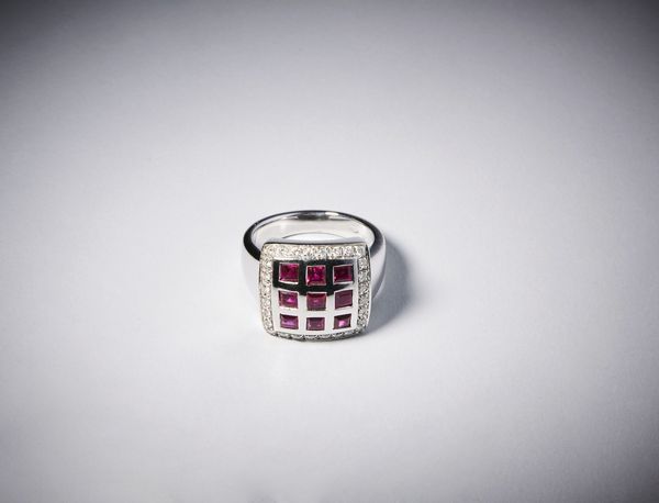 . : Anello in oro bianco 750/1000 con carr� di rubini di circa  0,70 carati contornati da piccoli diamanti bianchi di circa 0,60 carati.  - Asta Asta 366 | GIOIELLI - OROLOGI - Giunonicae Online - Associazione Nazionale - Case d'Asta italiane