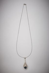 . - Deliziosa collana in oro bianco 750/1000  con pendente  ''Art Deco''  con zaffiro blu cabochon di circa 4,00 carati  e diamanti bianchi di circa 0,35 carati.