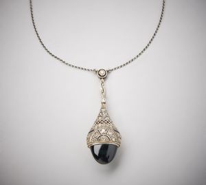 . : Deliziosa collana in oro bianco 750/1000  con pendente  ''Art Deco''  con zaffiro blu cabochon di circa 4,00 carati  e diamanti bianchi di circa 0,35 carati.  - Asta Asta 366 | GIOIELLI - OROLOGI - Giunonicae Online - Associazione Nazionale - Case d'Asta italiane