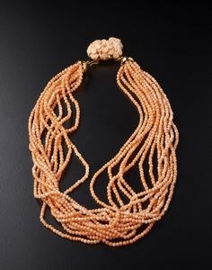 . - Collana multifilo in corallo rosa con pendente di corallo inciso di forma floreale e chiusura in oro giallo 750/1000.