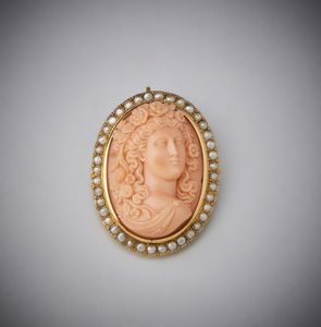 . - Spilla in oro giallo 750/ 1000  con corallo rosa inciso raffigurante Venere contornata da perline .