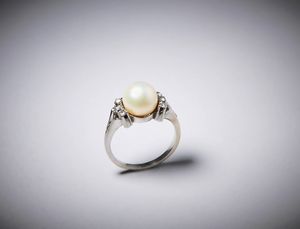 . - Anello in oro bianco 750/1000 con perla sferica e brillantini taglio huit huit di circa 0,40 ct.