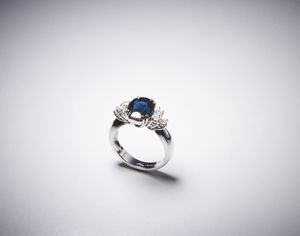 . - Elegante anello in oro bianco 750/1000 con zaffiro blu  taglio ovale di circa 4,00 ct e diamanti taglio a brillante di circa 0,40 ct.