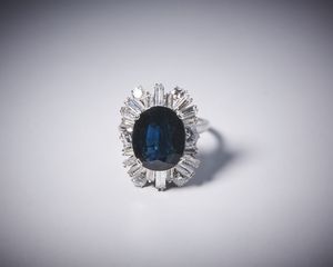 . : Anello artigianale in oro bianco 750/1000 con diamanti bianchi taglio a brillante per tot. 1,50 ct circa e diamanti bianchi taglio a baguette di 3,50 ct circa con zaffiro blu centrale 7,50 ct circa.  - Asta Asta 366 | GIOIELLI - OROLOGI - Giunonicae Online - Associazione Nazionale - Case d'Asta italiane