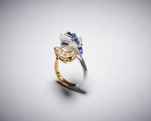 . - Anello bicolore oro giallo e bianco 750/1000 contrariè con diamanti taglio a brillante e zaffiri blu.