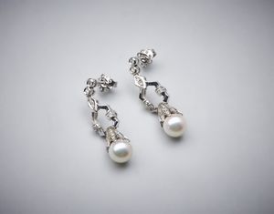 . - Orecchini pendenti in oro bianco 750/1000 con coppia di perle sferiche bianche coltivate di mm 8,50 e piccoli diamanti bianchi di taglio misto di 0,80 ct circa.