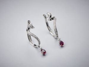 . - Orecchini pendenti in oro bianco 750/1000 a semicerchio con coppia di rubini per tot. 2,70 ct circa taglio a goccia con pav di diamanti bianchi interni ed esterni per un totale di 1,50 ct circa.