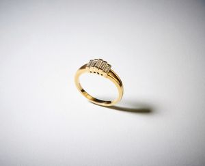 . - Anello in oro giallo 750/1000  con cinque diamanti bianchi taglio baguette per totali 1,00 carati circa.