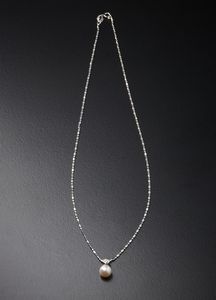 . - Catena in oro bianco 750/1000  con maglia tipo diamantata, piccolo brillantino taglio brillante ct: 0.10 e perla bianca coltivata mm: 7,50.
