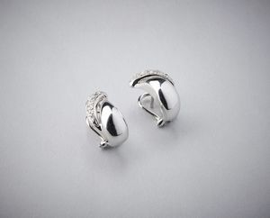 . - Orecchini in oro bianco 750/1000  tipo virgole bombate con pav di piccoli brillanti ct: 0,30.