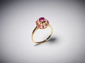 . - Anello tipo fascetta con rubino centrale ct: 0,70 contornato da diamanti taglio a brillante e rubini taglio brillante ct: 0,45 e 0,40.