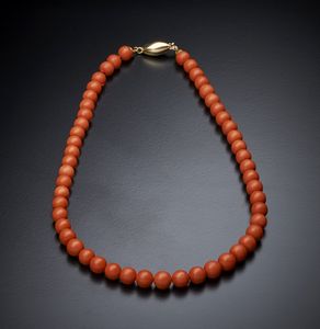 . - Filo di corallo rosso a pallini sferici con chiusura in oro giallo 750/1000 ovale bombata.