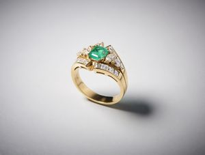 . - Anello oro giallo  750/1000 con smeraldo centrale taglio a cuscino di circa 1,10 carati  e diamanti bianchi di taglio misto di circa 1,35 carati.