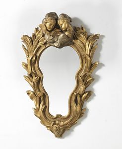 MANIFATTURA DEL XVIII SECOLO - Specchiera in legno dorato decorata con motivi vegetali e una coppia di putti alati sulla sommità