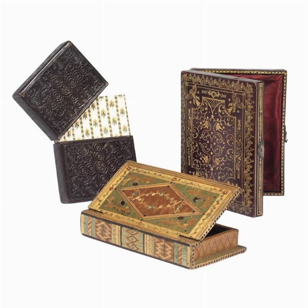 (Legature)   Lotto di 3 astucci per libri. XVIII-XIX secolo.   Una custodia a tasca in marocchino scuro decorato a secco, ca. 117 x 80 x 17 mm. Una scatolina a forma di libro in legno intarsiato, ca. 130 x 75 x 23 mm (spazio interno 112 x 54 x 13 mm). Altra bella scatolina in vitellino bordeaux riccamente decorato in oro, piedini e fermaglio in metallo, interno morbido rivestito in seta moire&eacute; boreaux, ca.130 x 97 x 24 mm.  - Asta Libri, manoscritti e autografi - Associazione Nazionale - Case d'Asta italiane