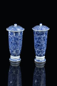 COPPIA DI VASI - Coppia di vasi in porcellana bianca e blu con decori floreali e tappo  Cina  dinastia Qing  Epoca Kangxi (1662-1722).  [..]