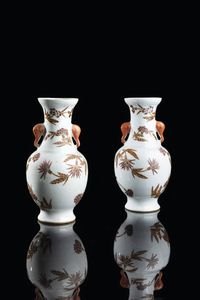 COPPIA DI VASI - Coppia di vasi in porcellana con decori floreali e manici a forma di elefante  Cina  dinastia Qing  XX secolo.  [..]