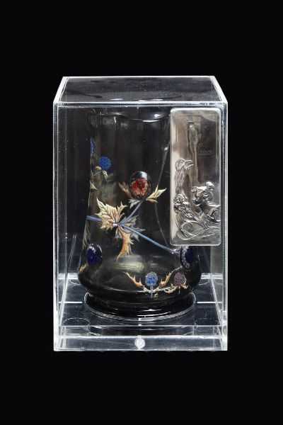 GALLE' : H. cm 21 8 Importante vaso in vetro bianco trasparente a sezione esagonale  riposante su base circolare. Decoro finemente dipinto a smalti Champlev  in policromia di foglie e cardi  con ricchi cabochon applicati a caldo  incorporanti delicate polveri in vetrificazione colorate nella massa. Firma incisa alla ruota  sotto la base  raffigucarnte cardi con dicitura Emile Gall fecit e frasario. Epoca 1880-1883 circa Marcate rotture Entro scatola in plexiglass Scheda tecnica a cura del Dottor Franco Borga  - Asta Antiquariato, Argenti, Dipinti e Sculture - Associazione Nazionale - Case d'Asta italiane