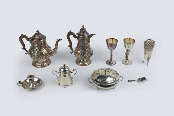 LOTTO DI NOVE OGGETTI IN ARGENTO : Peso complessivo gr 3419 1 Composto da: - 1 coppa con coperchio. Peso gr 235 0 - 2 calici con corpo recante figure orientaleggianti di geisha e pescatore. Peso gr 511 1 - 1 paletta per zucchero. Peso gr 19.6 - 1 vasetto di forma cilindrica con brodo traforato a motivi di palmette; poggiante su tre piedini. Peso gr 193 9 - 1 bugia. Peso gr 132 9 - 1 piccola legumiera. Peso gr 467 9 - 1 caffettiera in argento 925/1000  firmata R. Alberti  corpo bombato e sbalzato con motivi vegetali; presa geometrica; manico in legno. Peso gr 860 2 - 1 teiera  in argento 925/1000  firmata R. Alberti  corpo bombato e sbalzato con motivi vegetali; presa geometrica; manico in legno. Peso gr 998 5  - Asta Antiquariato, Argenti, Dipinti e Sculture - Associazione Nazionale - Case d'Asta italiane